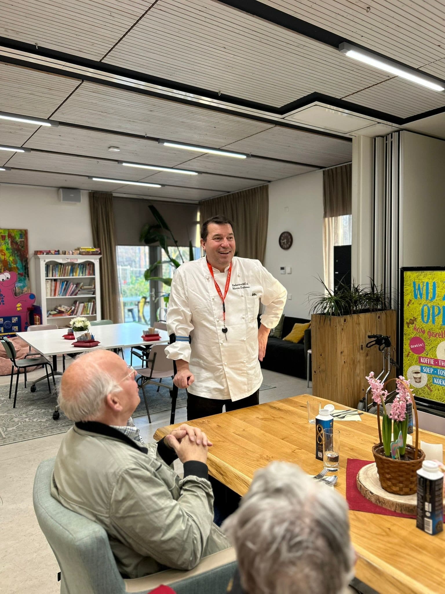 Mexicaanse avond: chef in witte koksjas in gesprek met gasten aan tafel in de zaal.