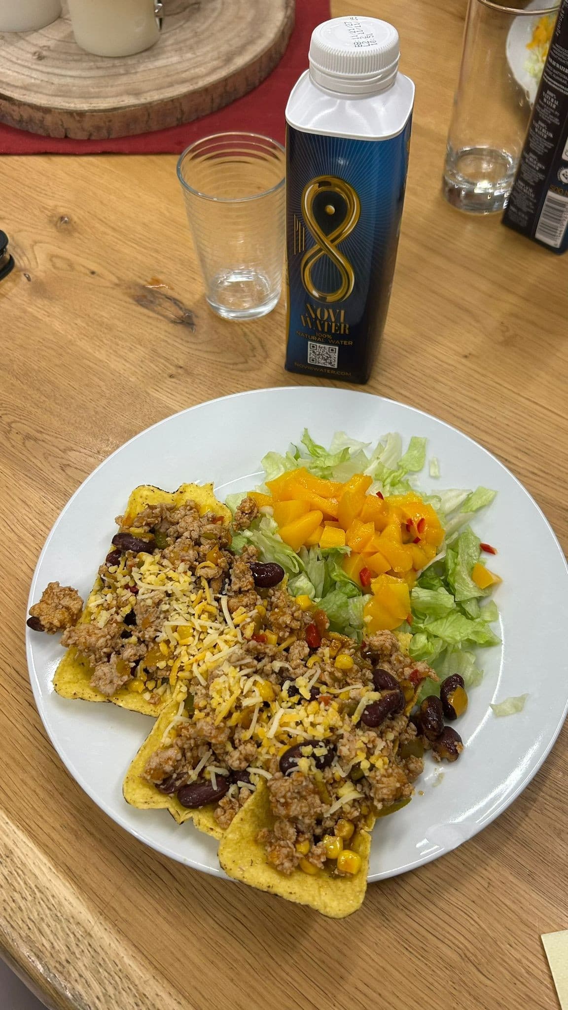Mexicaanse avond: bord met taco’s, bonen, mais en frisse salade op een houten tafel.