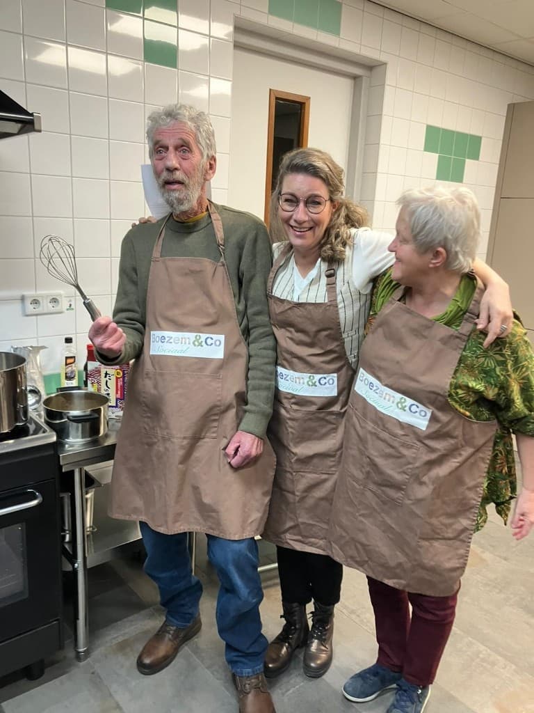 Oosterse avond januari 2026: drie deelnemers in keukenschorten Boezem & Co Sociaal, gezellig samen in de keuken.